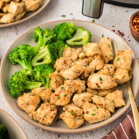 Garlic parmesan chicken bites on plate with broccoli.