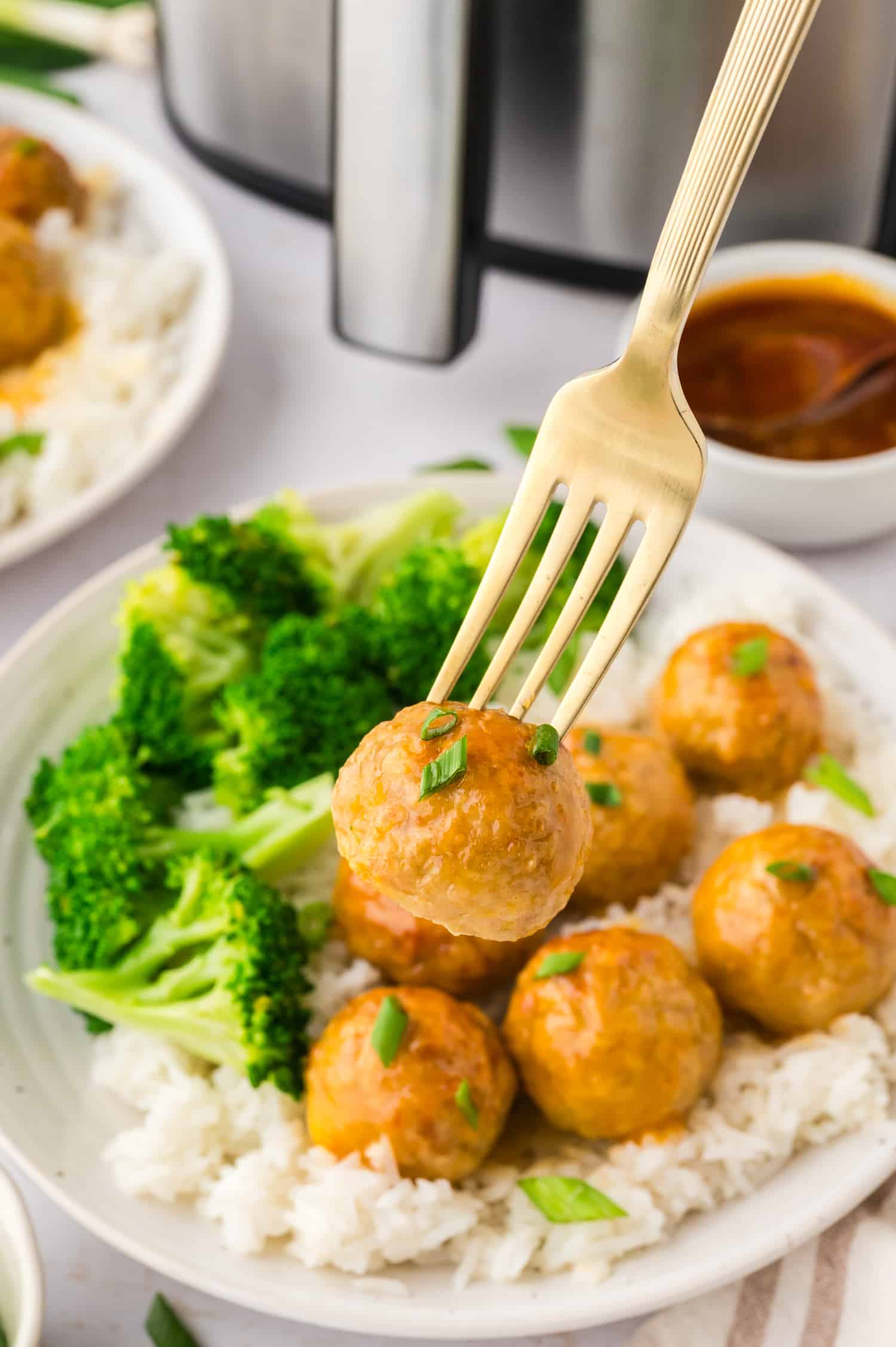 Hot honey chicken meatball on a fork.