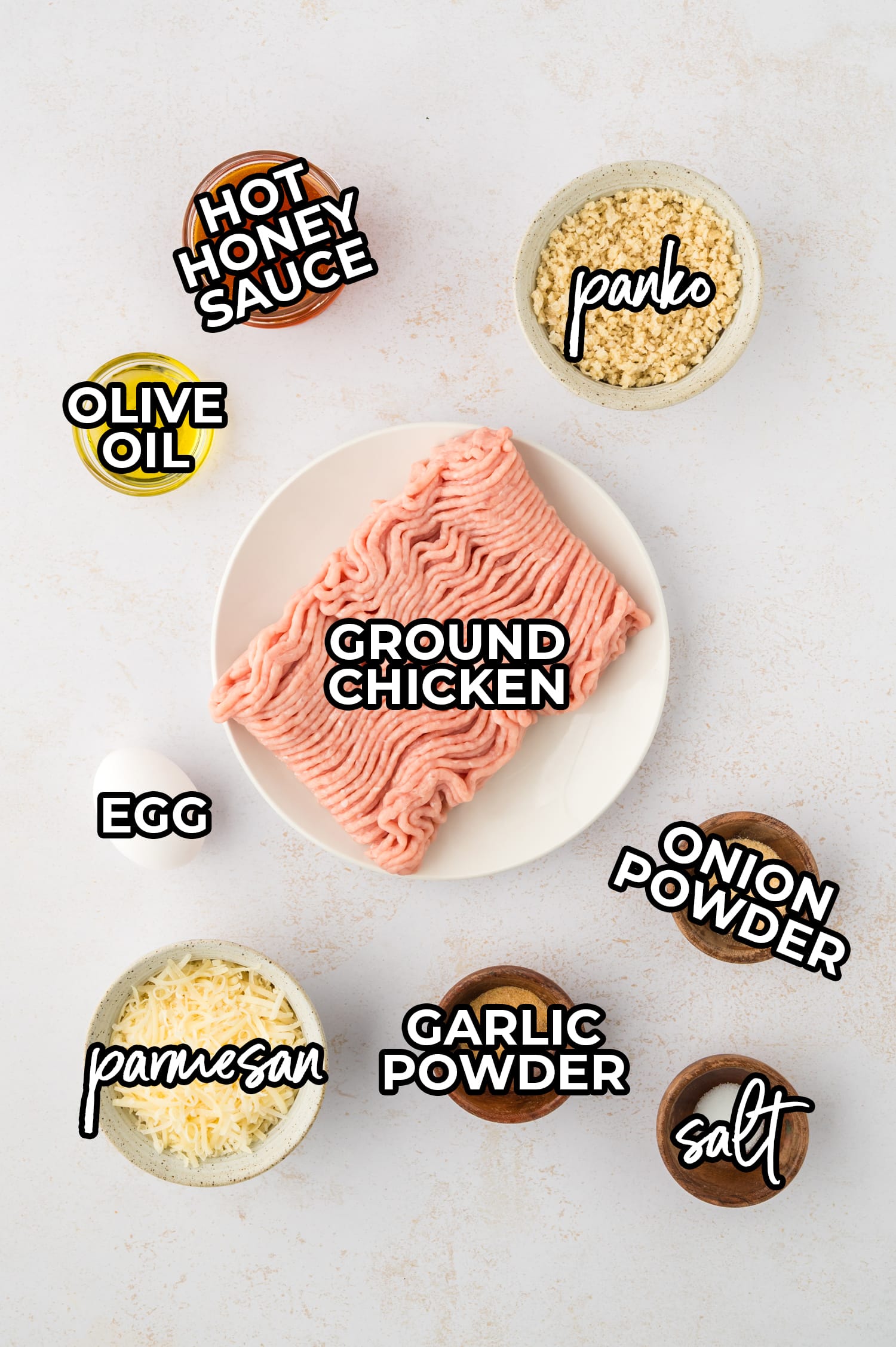 Ingredients for hot honey chicken meatballs are arranged on a white countertop, each labeled for clear identification.