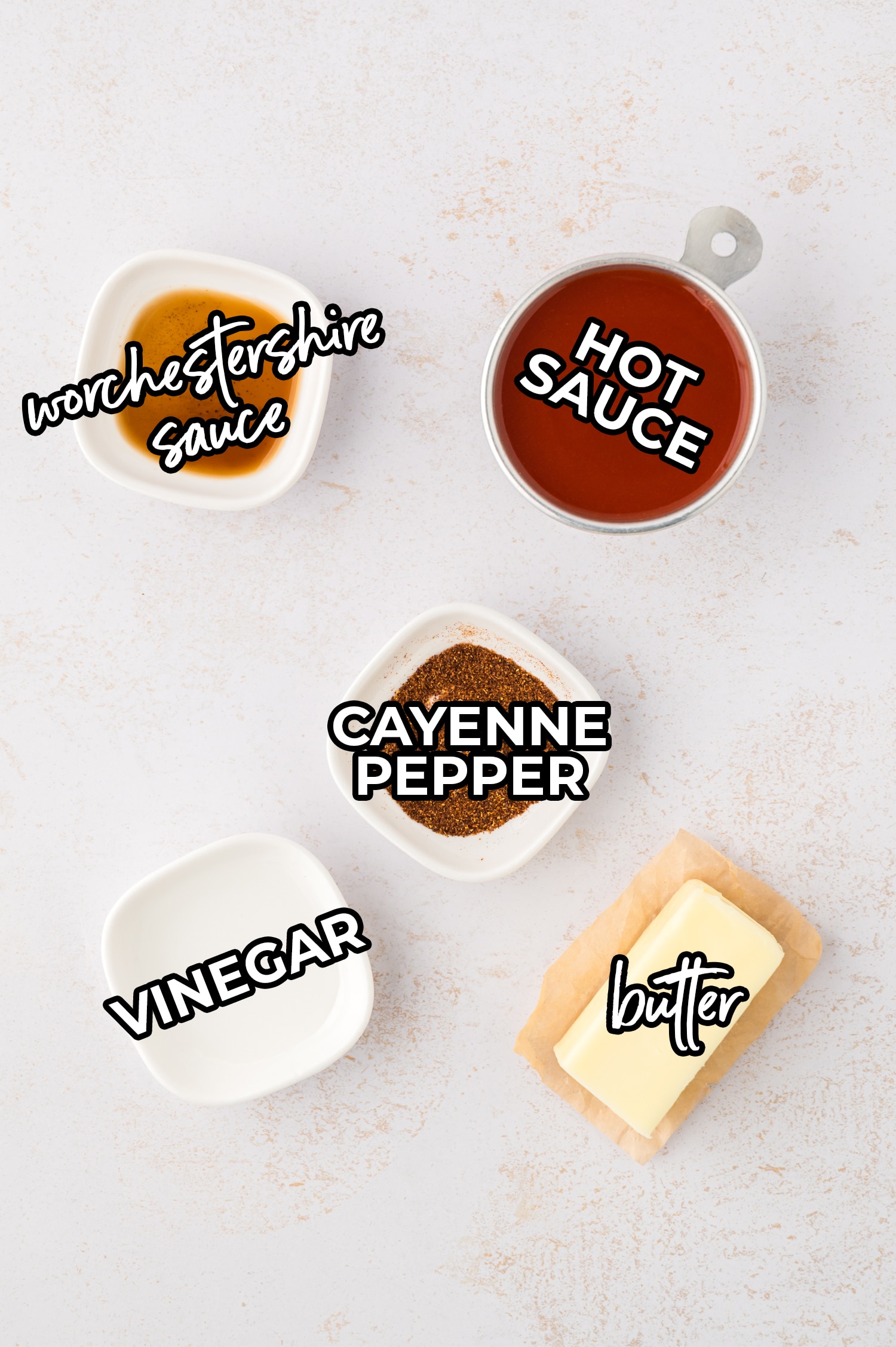 Buffalo sauce ingredients are spread across a white countertop, each item set out separately so the components are clearly visible.