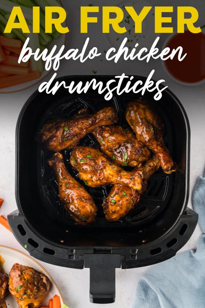 An overhead view of buffalo chicken drumsticks arranged in a single layer inside an air fryer basket.