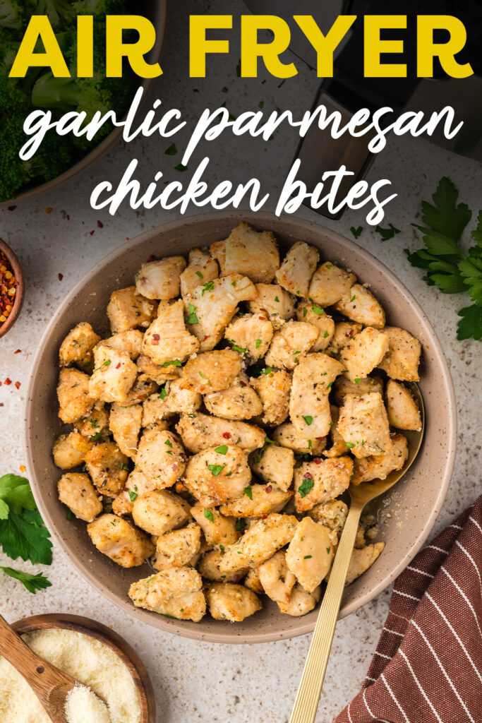 A spoon in a bowl full of garlic parmesan chicken bites.