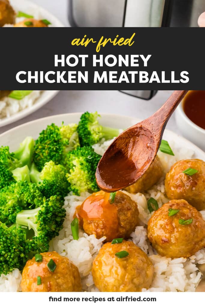 A wooden spoon drizzles hot honey over a chicken meatball served on a bed of rice.