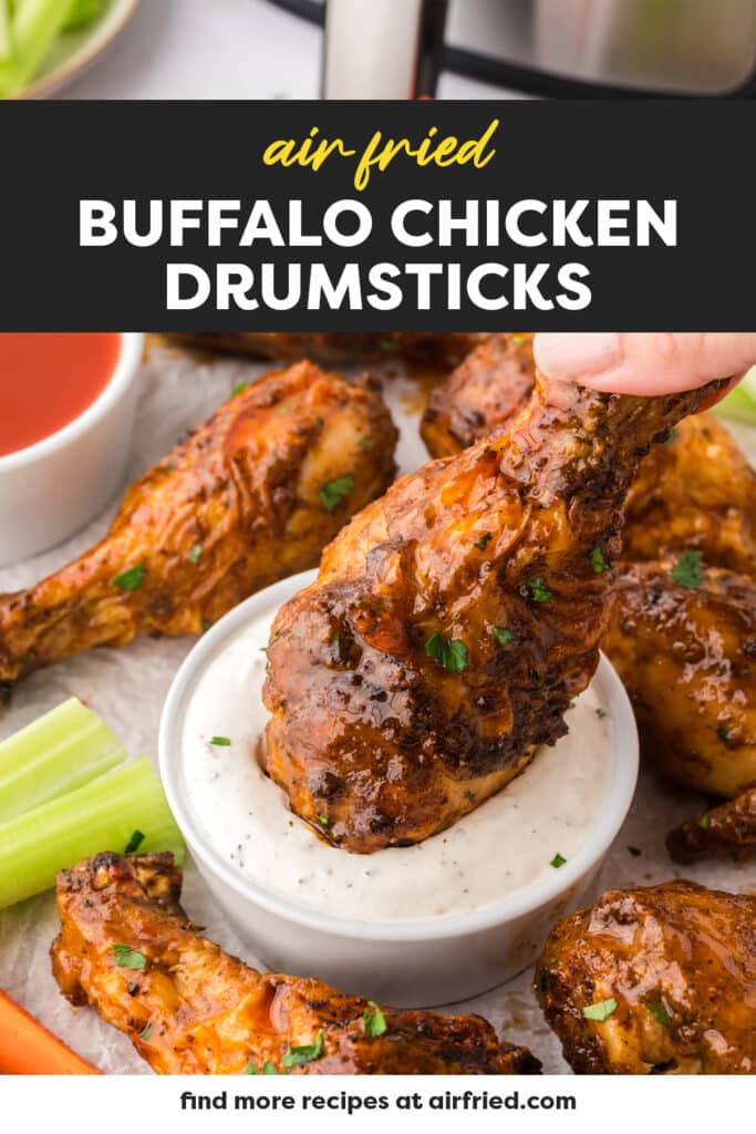 Buffalo chicken drumstick being dipped into ranch dressing.