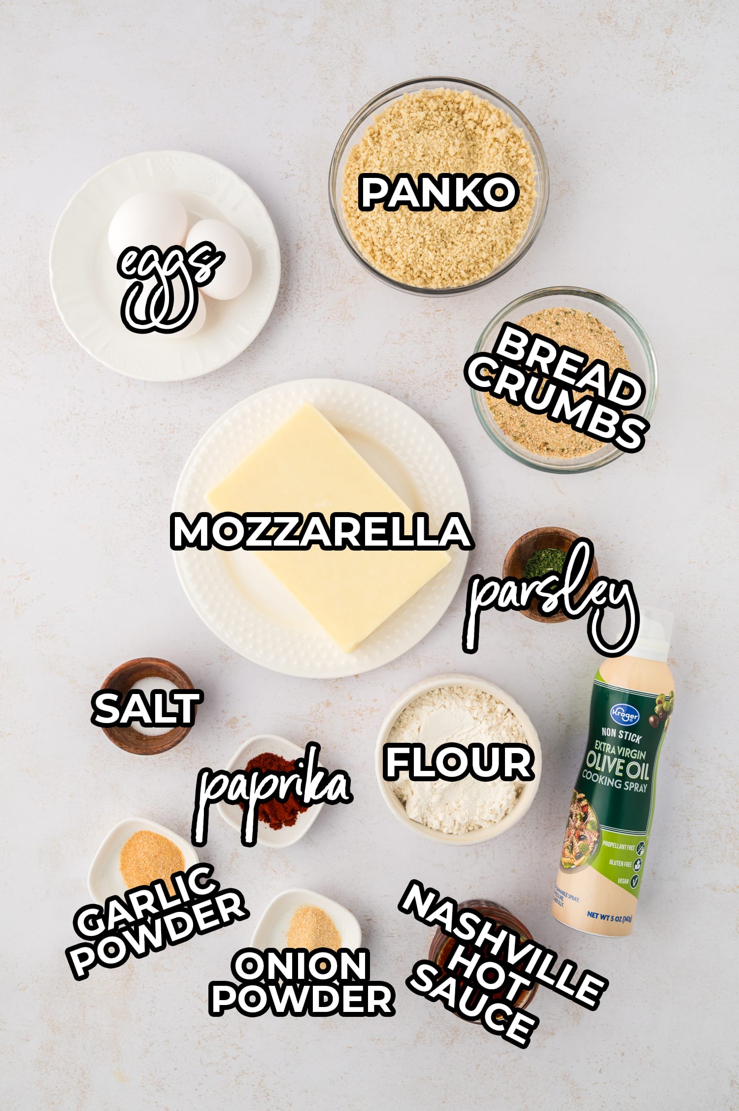 Ingredients for Nashville hot mozzarella sticks are arranged on a white countertop, each labeled for clear identification.