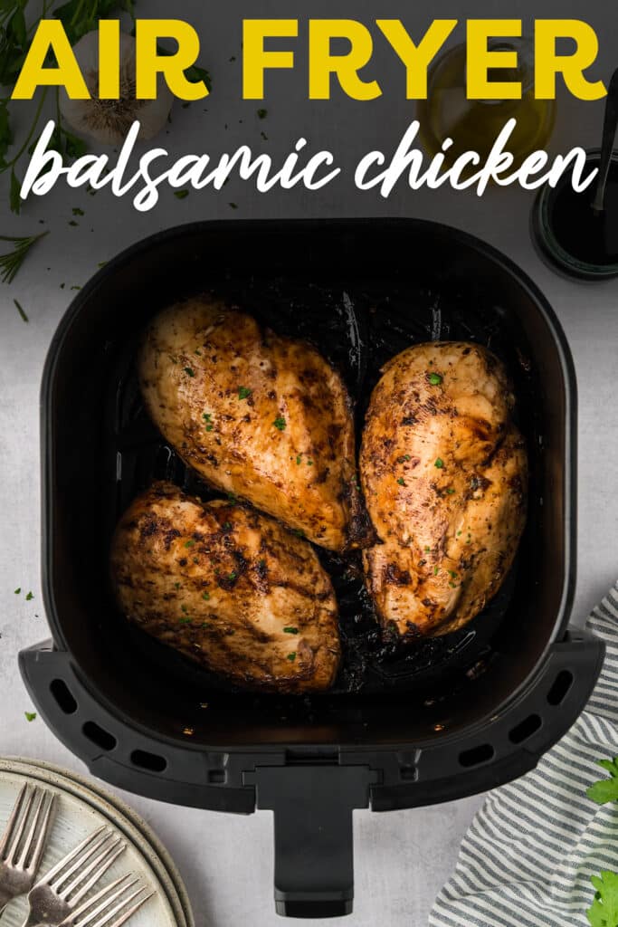 Three balsamic chicken breasts are arranged in a single layer inside an air fryer basket.
