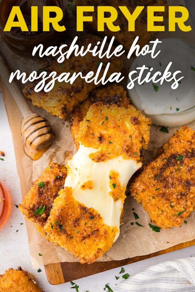 A close-up of a Nashville hot mozzarella stick pulled apart, with melted cheese stretching between the two halves and a red, seasoned coating on the outside.