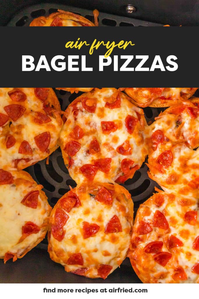 Eight bagel pizzas are arranged in a single layer inside an air fryer basket.