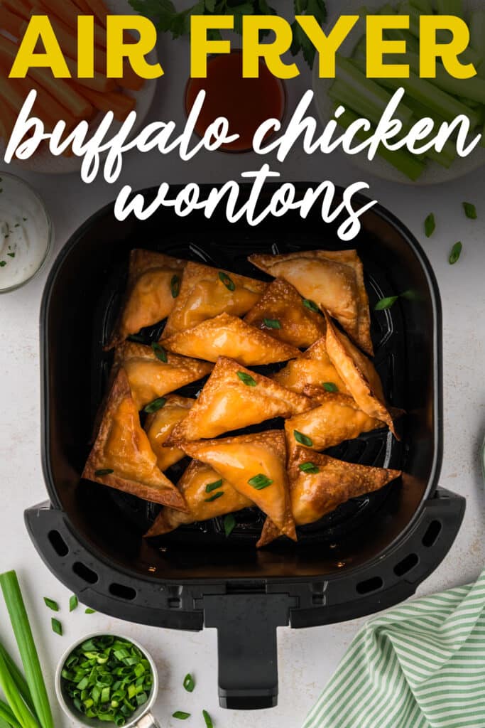An overhead view of an air fryer basket filled with cooked buffalo chicken wontons arranged in a single layer.