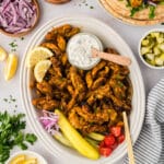 Overhead view of a plate full of chicken shawarma surrounded by toppings.