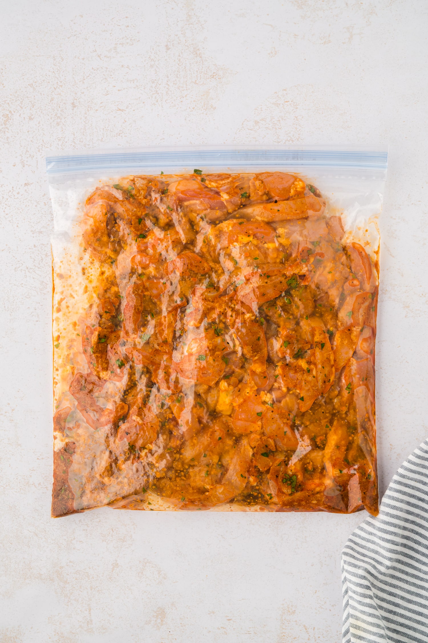 Cut raw chicken in a freezer bag.