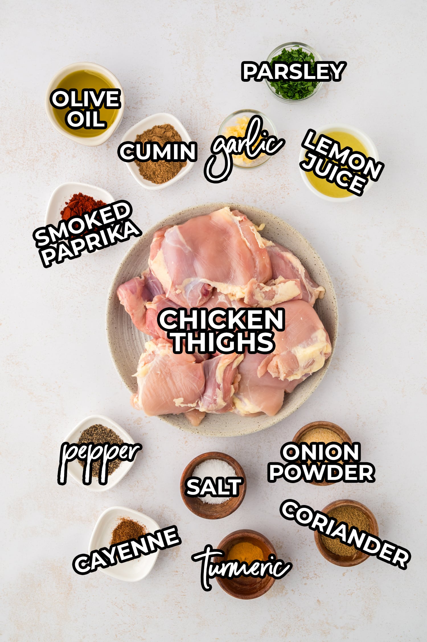 Ingredients for chicken shawarma spread out and labeled on a white countertop.