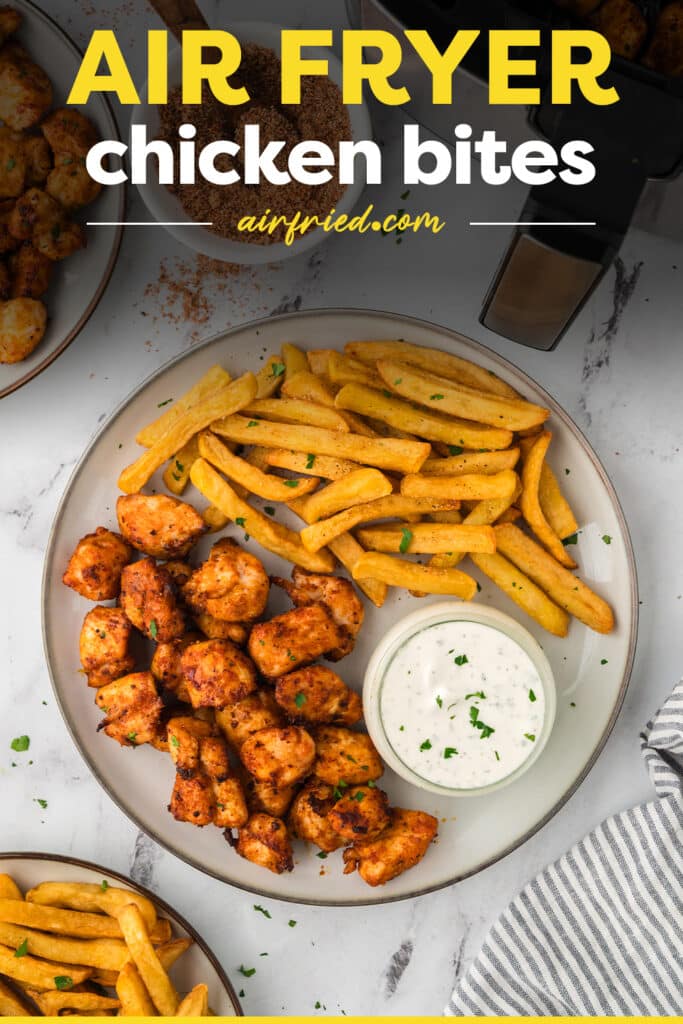 Chicken bites and french fries on a white plate