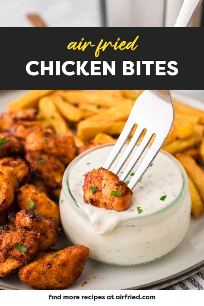 A fork dipping a chicken bite into ranch dressing.