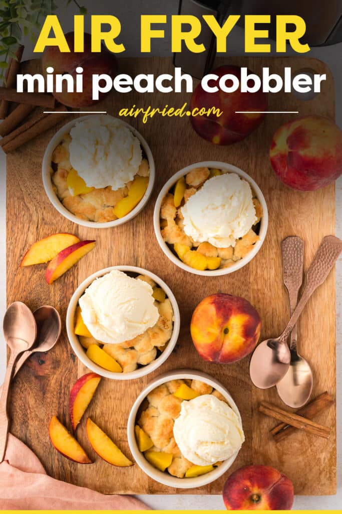 Four individual peach cobbler servings in their ramekins are arranged on a wooden cutting board.