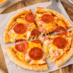 Sliced pita pizza on a wooden serving tray.