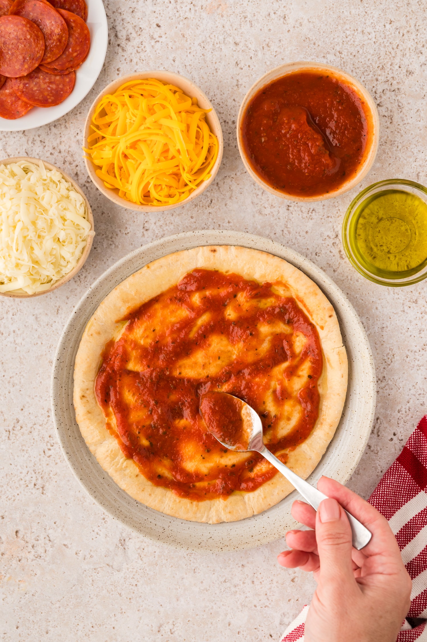 Sauce being spread on a pita.
