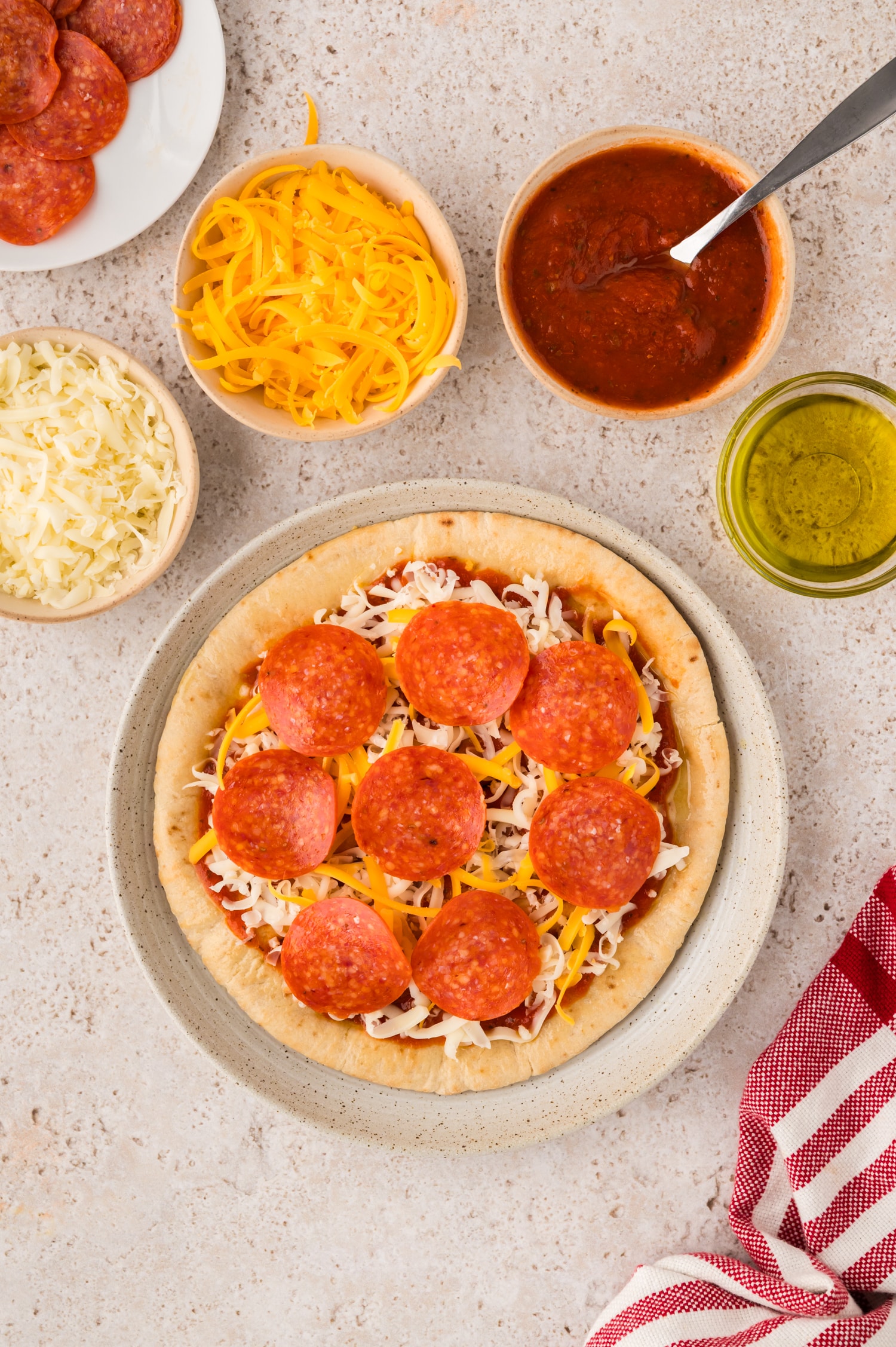 An assembled pita pizza before cooking.