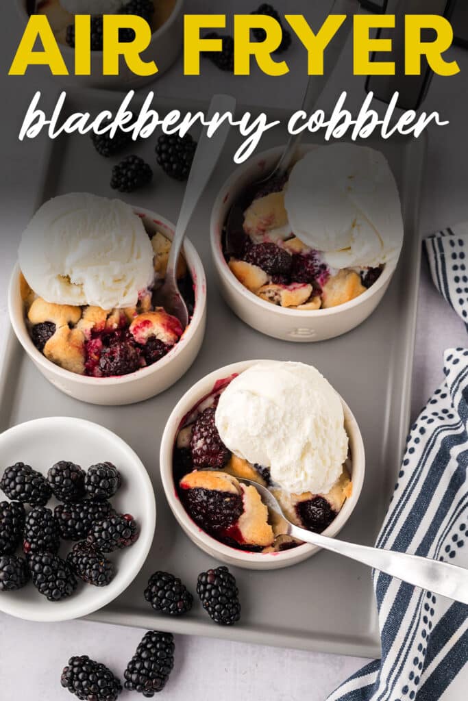 Three ramekins of blackberry cobbler with ice cream on top.