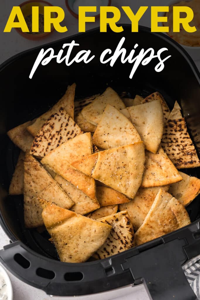 An air fryer basket filled with cooked, seasoned pita chips.