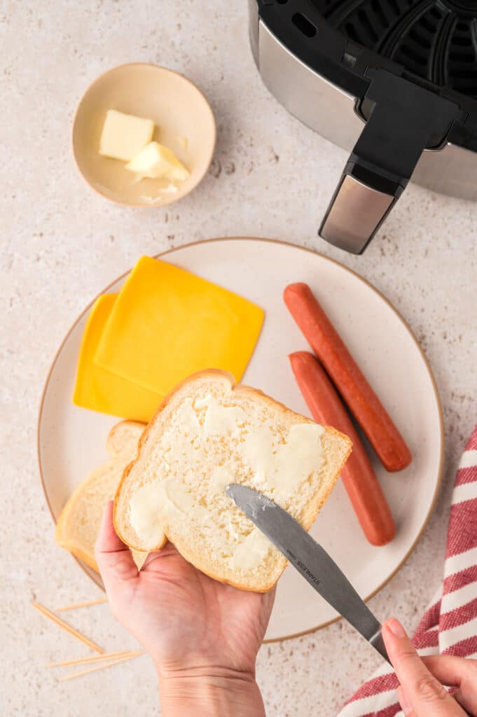 Butter being applied to a piece of bread.