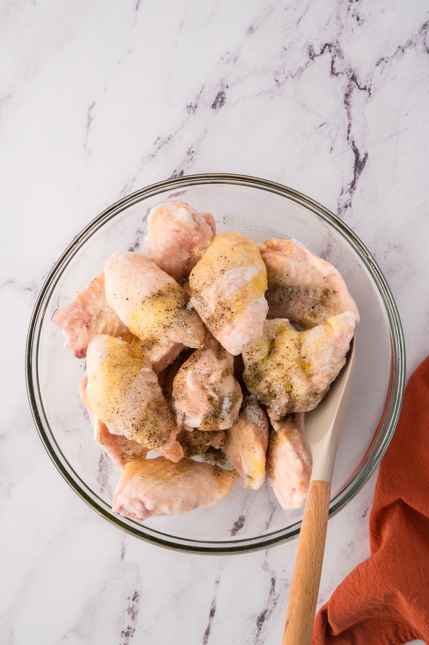 Frozen wings drizzled with oil and seasoning.