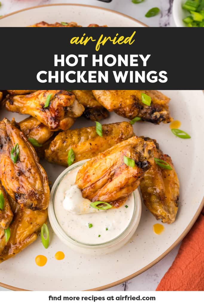 Hot honey chicken wing being dipped in ranch.
