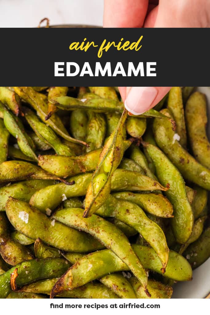 Close up of a person holding a split open edamame.