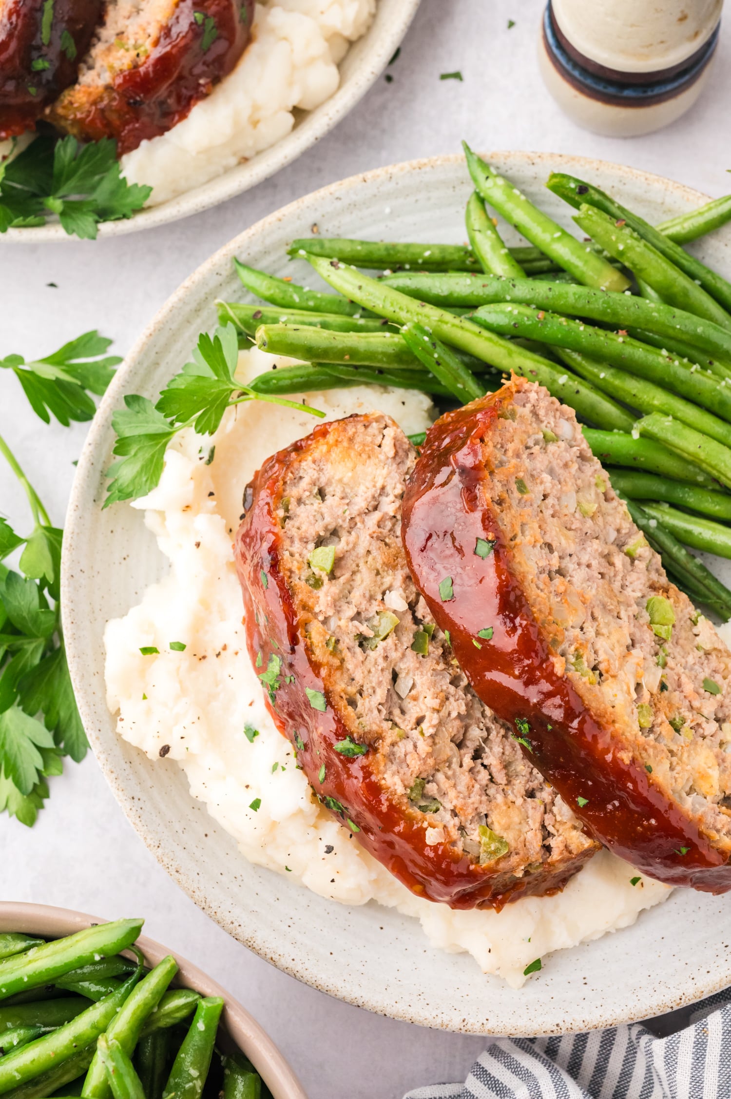 Close up of turkey meatloaf being served on a plate with mashed potatoes.