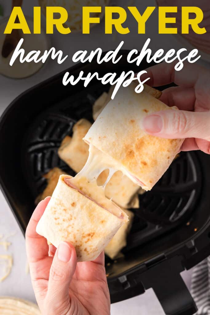 A person pulling apart a cut air fryer ham and cheese wrap.